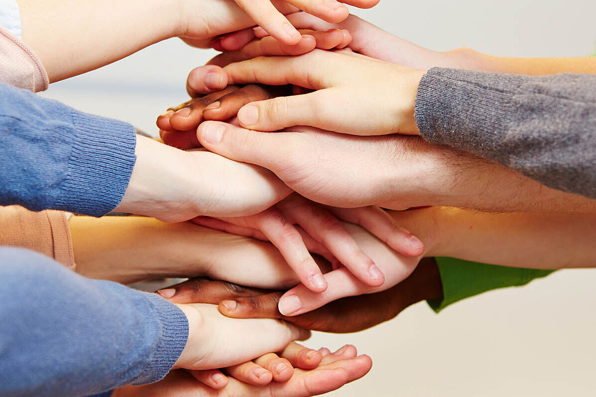 Für Chancengleichheit in Bildung und Teilhabe (Foto: Robert Kneschke / Fotolia) Mehrere Menschen stapeln ihre Hände aufeinander.