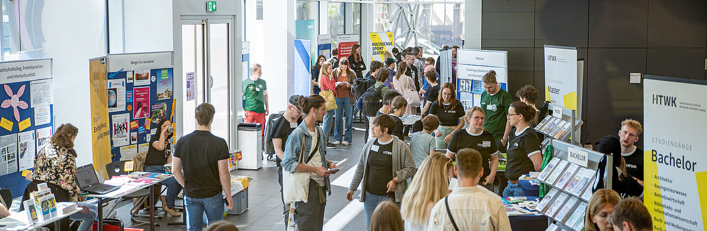 Hochschulinformationstag an der HTWK Leipzig Blick in ein helles und großzügiges Foyer mit vielen Ständen zur Studienorientierung und vielen Personen
