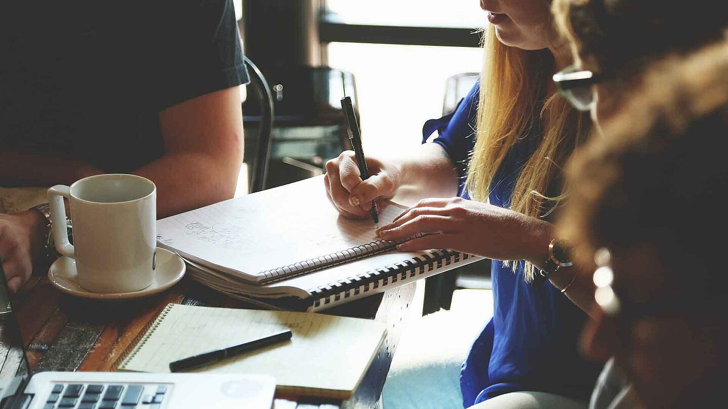 Foto: Pixabay Mehrere Menschen sitzen an einem Tisch und besprechen etwas