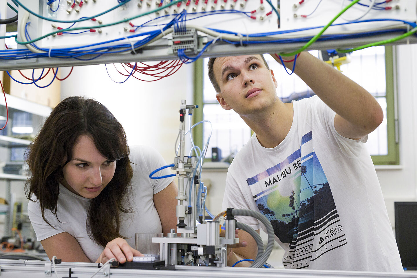 Zwei Personen arbeiten an der Elektrik in einer Werkstatt